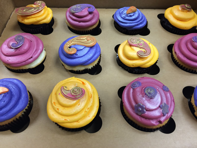 Multicolored jumbo cupcakes with yellow, blue and purple buttercream icing
