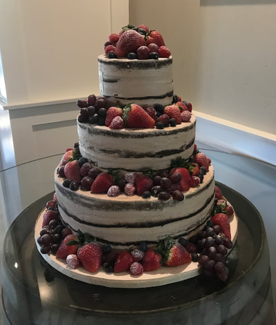 Large 3 tier naked cake for a wedding with fresh fruit all around including grapes, strawberries, raspberries.
Click here for larger image.